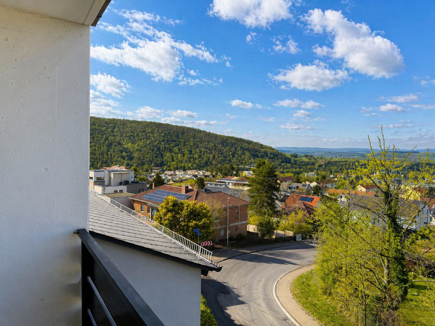 Balkonblick in Richtung bewaldeter Hanglage und Wohnumfeld am Kuhberg