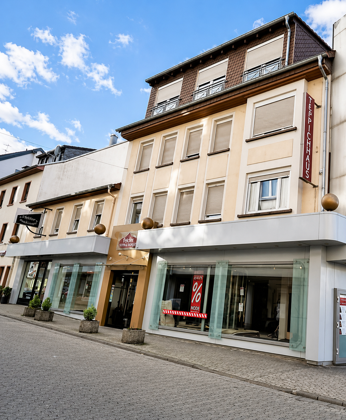 Straßenansicht des Objekts mit Ladenfronten und Fassadenbezug im Stadtraum